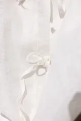 Blusa negra de lino con mangas balloon, largo a la cadera, cuello a la base y cierre con tiras.