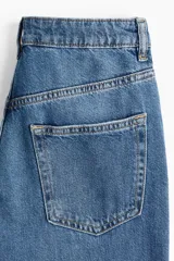 Pantalón de jean azul denim de corte ancho, tiro alto y cinco bolsillos.