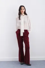Pantalón de terciopelo color borgoña, estilo oxford, con acceso por cartera oculta con cierre, gancho metálico y botón interno en cintura. Bolsillos diagonales y bolsillo ojal en espalda.