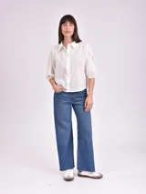 Camisa blanca de mangas 3/4 con detalles de calado en las mangas.