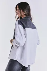 Campera de jean combinada con cuerpo de denim negro y mangas blancas.