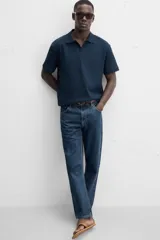Polo azul marino de punto con textura acanalada vertical, corte regular fit, cuello solapa con abertura frontal y mangas cortas.