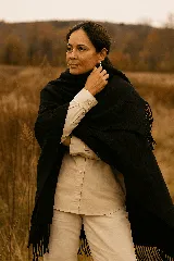 Ruana negra con flecos tejida en lana merino.