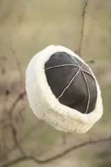 Gorro negro de cuero con borde de corderito gris.