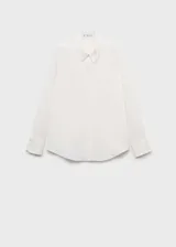 Camisa blanca de tejido fluido, corte recto, cuello camisero, cierre frontal con botones y mangas largas con puños abotonados.