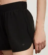 Short deportivo femenino color blanco, de poliéster, con cintura elástica, abertura lateral y bolsillo trasero.