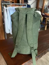 Mochila verde con diseño robusto y cierre frontal, ideal para uso diario.