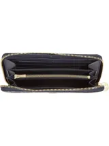 Billetera Tommy Hilfiger con cierre de cremallera, diseño integral con monogramas TH en relieve y insignia del monograma TH en la parte delantera.