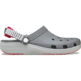 Zueco Crocs Classic Turbo, color gris con detalles en blanco y rojo. Cuenta con correa trasera ajustable, suela de goma para mejor tracción y orificios para colocar charms Jibbitz.