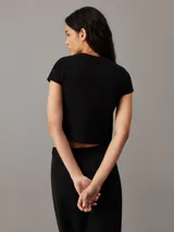 Remera negra de algodón, corte slim cropped, cuello redondo y mangas cortas.