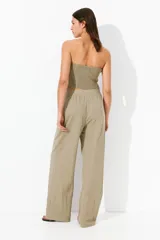 Pantalón de vestir color beige con pinzas, tiro alto, cintura elástica, bolsillos al bies y piernas amplias con raya adelante. Corte relajado.