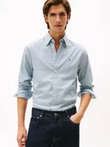Camisa de manga larga Tommy Hilfiger con estampado Tattersal en tonos celeste y blanco. Confeccionada en tejido Oxford de algodón regenerativo, con cuello abotonado, cierre con botones y logo bordado en el pecho.