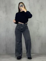 Pantalón de jean gris oscuro, corte wide leg, tiro alto y bolsillos frontales con cierre.