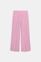 Pantalón negro de tiro alto con corte palazzo, bolsillos laterales y pliegues frontales. Cierre frontal con cremallera y botón.