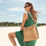 Cartera marrón de cuero sintético con apertura superior y cierre. Tiene detalle de costuras en el frente, dos bolsillos internos, un bolsillo divisor en el forro y bolsillos laterales con cierre. Incluye correa larga regulable.