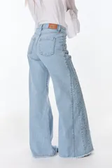 Pantalón de jean celeste de corte wide leg con terminación desflecada.
