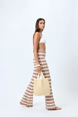Pantalón tejido con motivo zigzag en tonos beige y blanco, de corte flare y cintura elastizada.