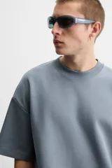 Sudadera negra de corte relaxed fit, confeccionada en tejido interlock de algodón con elasticidad. Tiene cuello redondo, manga corta y bajo acabado en rib.