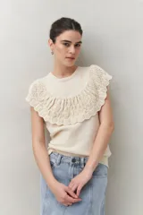 Chaleco color crema de tejido de punto, con cuello redondo y volados de crochet en el frente y la espalda.