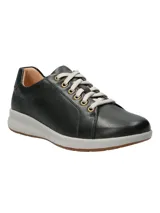 Zapatilla de cuero negro con cordones y suela blanca.