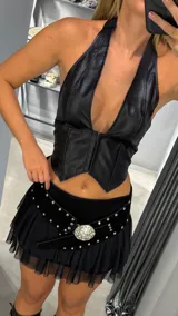 Corset negro de eco cuero con escote halter y cierre frontal con cremallera.