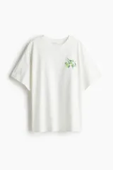 Remera blanca de corte amplio con estampado de rama de olivo en el pecho.