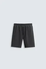 Bermuda de corte relaxed fit color gris oscuro, con cintura elástica ajustable con cordón, bolsillos frontales y bolsillo trasero de plastrón.