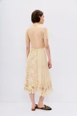 Vestido color crema con encaje floral, escote en V cruzado y mangas cortas con volados.