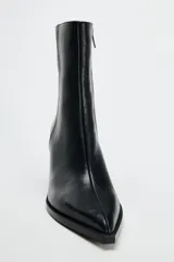 Botín de cuero negro con punta fina, cierre lateral con cremallera y tacón ancho de 6 cm.