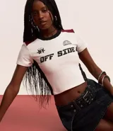Blusa corta de algodón color blanco con mangas cortas, cuello redondo y bloques de colores en contraste en los laterales y en los hombros. Tiene lettering "NY - American Off Side" estampado en el pecho.