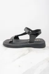 Sandalias negras de cuero con plataforma y tiras ajustables.