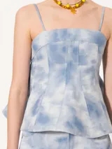 Top celeste con estampado tie-dye, escote recto, breteles finos y corte peplum.