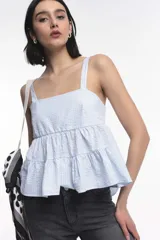 Top celeste con textura de cuadrillé, breteles anchos y volados en el ruedo.