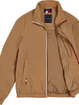 Campera de poliamida color khaki, con cierre frontales y detalles distintivos de Tommy Hilfiger, dos bolsillos delanteros y puños elásticos.