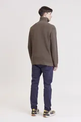 Sweater de punto color crema con cuello alto y cierre de cremallera parcial. Diseño de corte holgado y mangas largas.