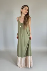 Vestido largo verde oliva con breteles finos y corte amplio. Tiene un ruedo en color beige.