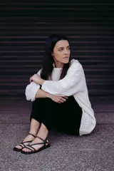 Sandalias chatitas negras de cuero con múltiples tiras finas y tachas doradas.