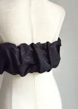 Top bandeau negro con textura fruncida y estampado abstracto plateado.