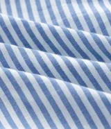 Vestido midi de tricolina con diseño de rayas celestes y blancas, escote cuadrado con lazo frontal, tirantes anchos y falda con volados escalonados.