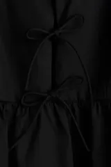 Vestido corto negro de popelina de algodón, con breteles spaghetti ajustables, escote redondo y abertura con tiras finas en el frente.