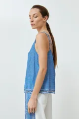 Top azul con estampado geométrico, breteles finos dobles y escote en V.