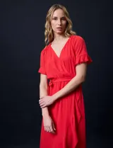 Vestido largo de gasa color rojo, con escote en V, mangas cortas con volados, cintura elastizada con lazo de ajuste y ruedo asimétrico con volados. Tiene forro interno a tono.