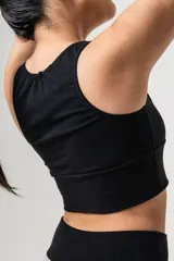 Top deportivo negro de algodón elastizado, con faja ancha y detalles en puntilla y algodón gris.