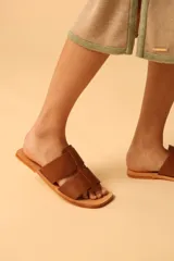 Sandalias plateadas con tiras anchas entrecruzadas y suela plana color camel.
