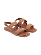Sandalia de cuero color marrón con tachas doradas, doble tira y pulsera de ajuste con hebilla.