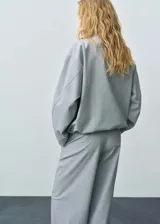 Anorak gris con cuello chimenea, diseño oversize y cierre de cremallera en el cuello.