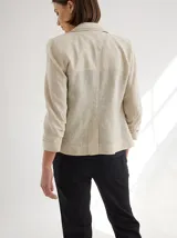 Blazer color mostaza de lino con corte estructurado, solapas con pespuntes y bolsillos con solapa.