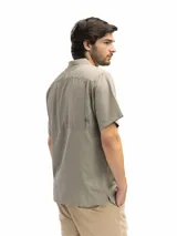 Camisa negra de manga corta con cuello clásico, cierre frontal con botones y bolsillo de parche en el pecho.