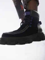 Botas de caña media color marrón de cuero gamuzado, con suela track y cordones rojos.