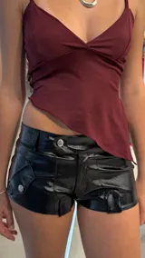 Short tiro bajo de vinilo negro con bolsillos laterales con botón.